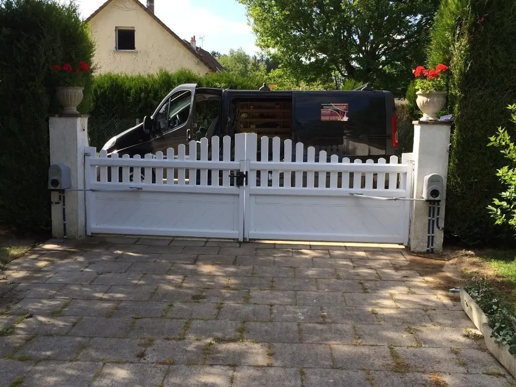 Portail blanc motorisé à l'entrée d'une propriété